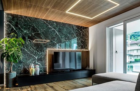 Sleek modern living room with dark marble accent wall, wood ceiling, and minimalist TV stand.