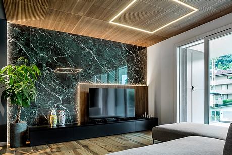 Sleek modern living room with dark marble accent wall, wood ceiling, and minimalist TV stand.