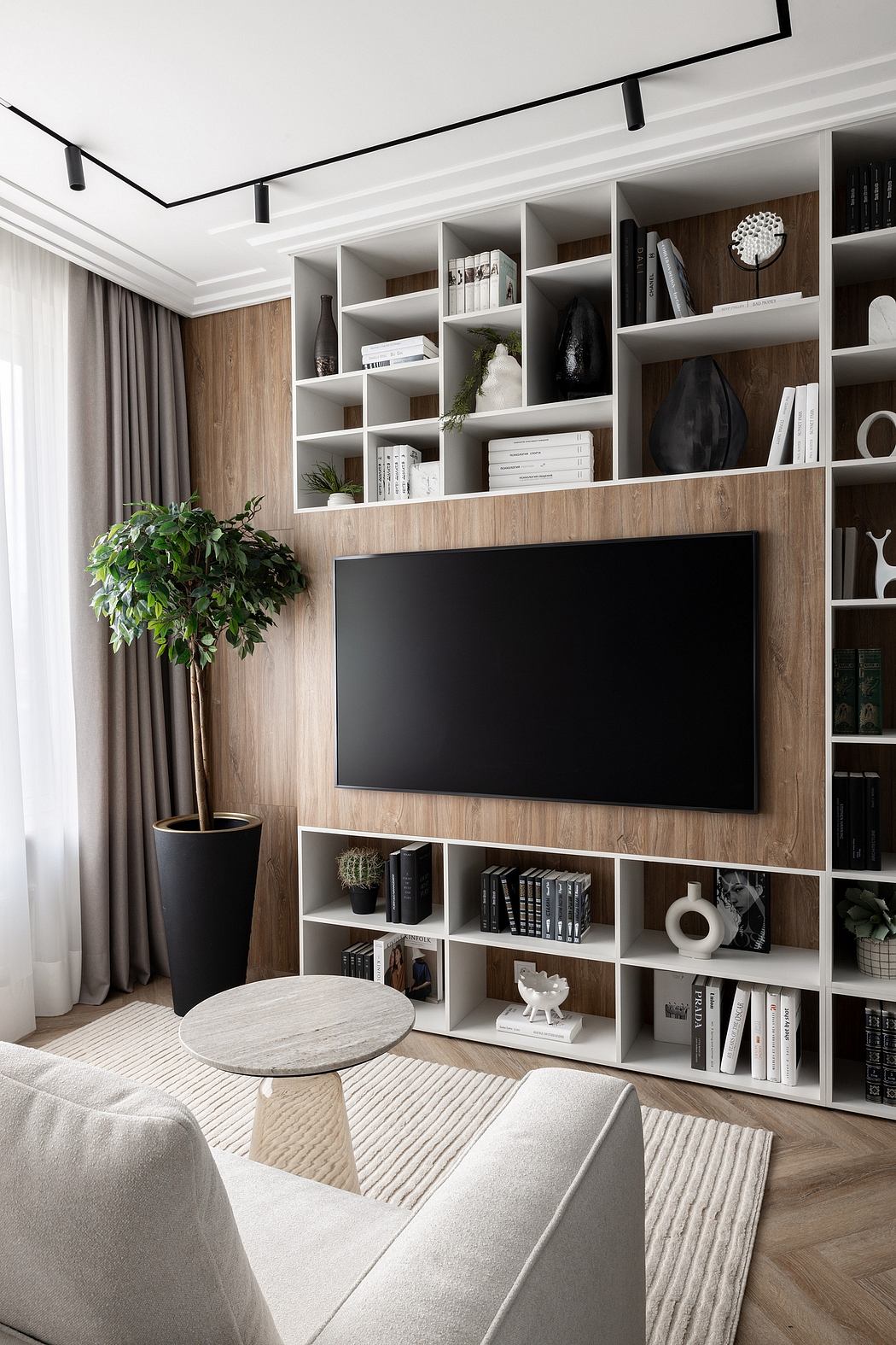 An elegant living room featuring a sleek TV unit with ample shelving and a cozy seating area.