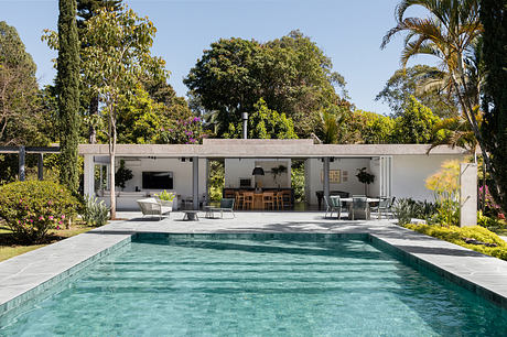 A modern, open-concept pool house with a sleek, minimalist design and lush, tropical surroundings.