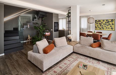 Spacious open-concept living area with modern furniture, artwork, and natural elements.