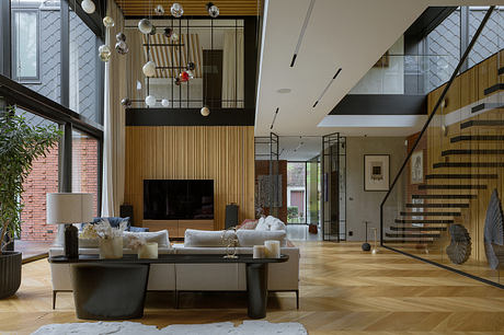 Spacious modern living room with wooden panels, hanging lamps, and a spiral staircase.