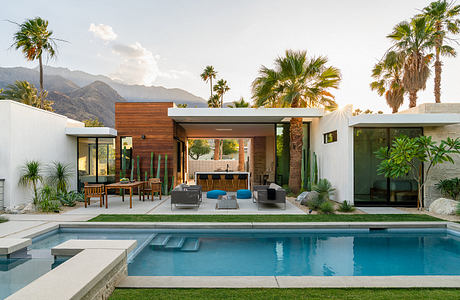 Modern desert home with pool, palm trees, and sophisticated outdoor living area.