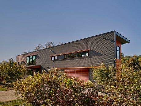 Large modern home with clean lines, wooden accents, and extensive glazing on the facade.