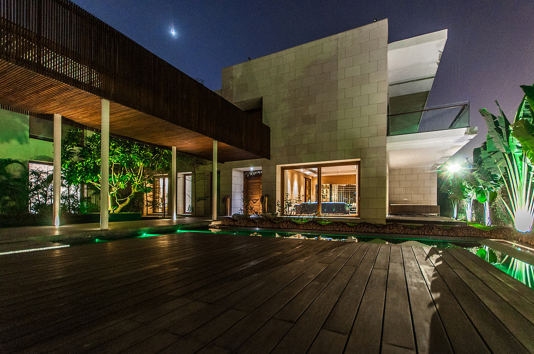Modern architectural design with wooden beams, stone walls, and a pool surrounded by tropical landscaping.