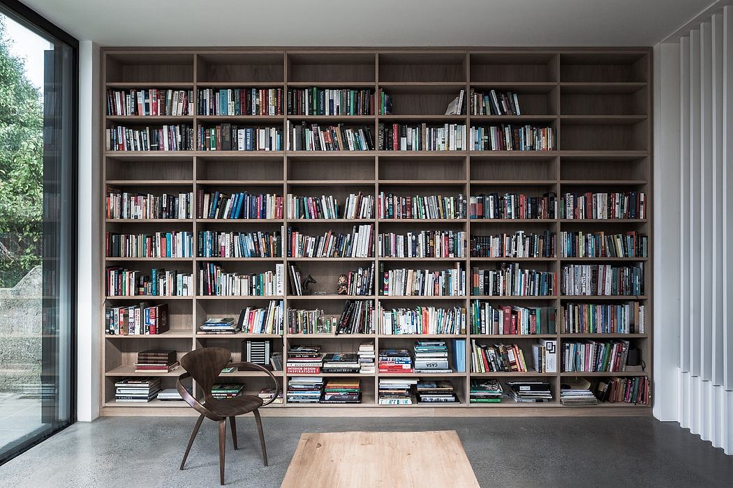 Spacious home library with extensive floor-to-ceiling bookshelves and a cozy chair.