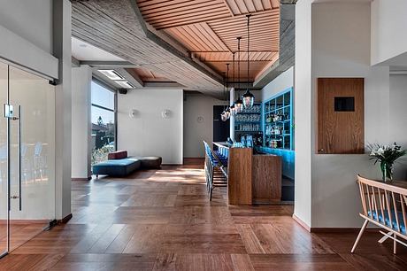 Modern, minimalist interior with wooden accents, sleek bar, and cozy lounge area.