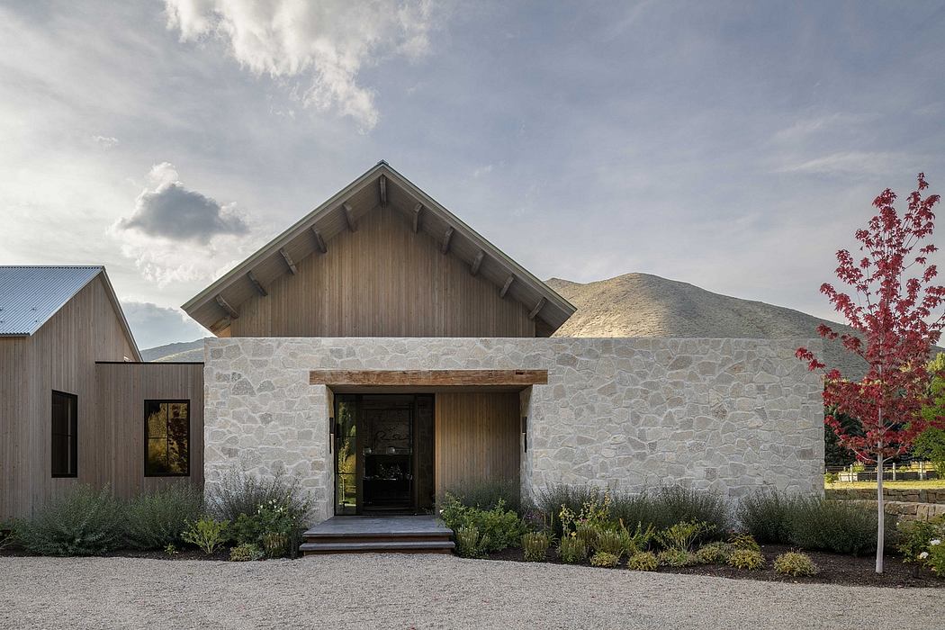 A rustic stone and wood-paneled residential building with a prominent gable roof.