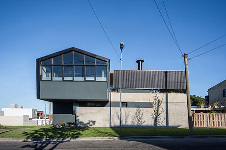 Modern glass and concrete building with a prominent cantilevered upper story.