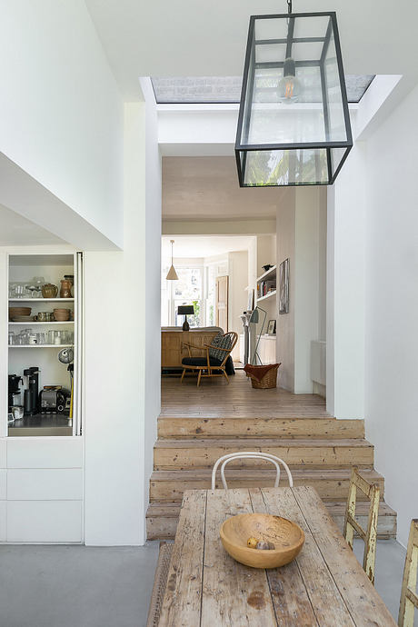 A bright, open space with a rustic wooden table, elevated by a modern glass pendant light.