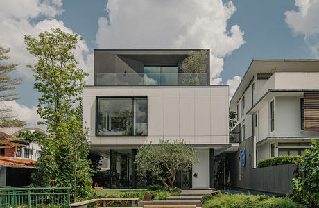 Modern multi-level building with large windows, glass balconies, and lush landscaping.