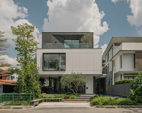 Modern multi-level building with large windows, glass balconies, and lush landscaping.