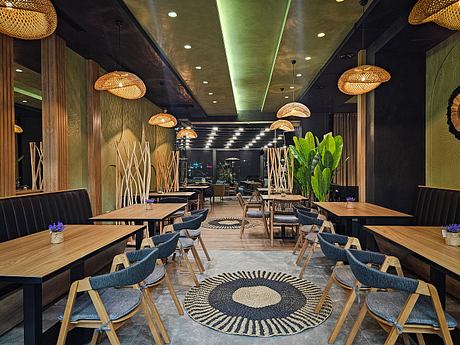 Warm, inviting restaurant interior with bamboo accents, tropical plants, and geometric decor.