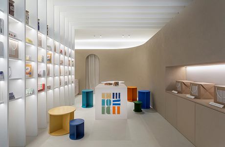 Minimalist retail space with modular furniture and color-blocked display shelves.