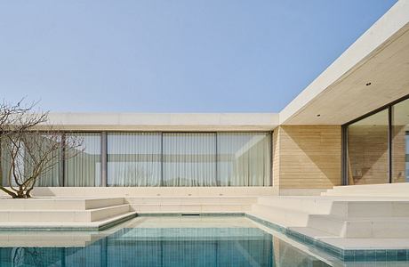 Sleek, modern architecture with clean lines, pool, and glass walls overlooking landscape.