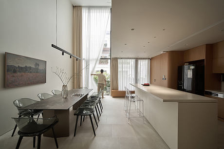 Sleek, modern kitchen with a minimalist dining area and large windows offering natural light.