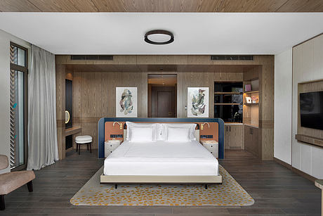 Modern bedroom with wooden paneled walls, minimalist furnishings, and abstract artwork.