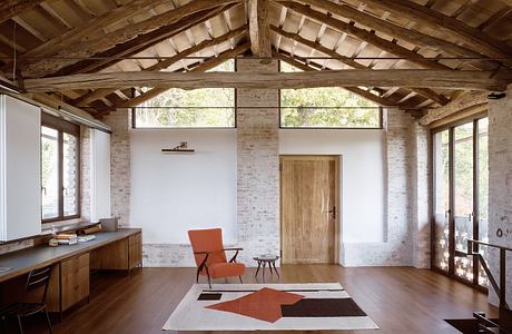 Rustic cabin interior with exposed wood beams, white walls, and modern furnishings.