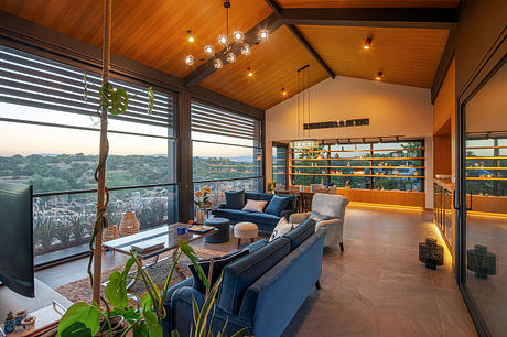 Cozy modern home with wooden beams, large windows, and eclectic furnishings.