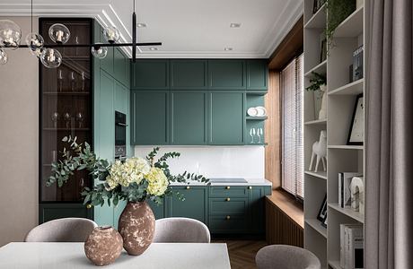 Elegant kitchen with wooden floors, lush greenery, and modern gray furnishings.