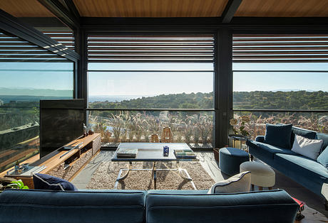 Stunning modern living room with floor-to-ceiling windows, sleek furnishings, and serene nature views.