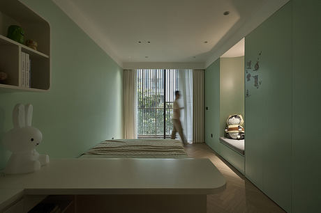 Serene, minimalist bedroom with green accent walls, large window, and built-in storage.