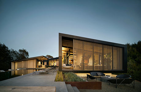 Contemporary modular architectural design with wooden facade, outdoor patio, and reflective pool.