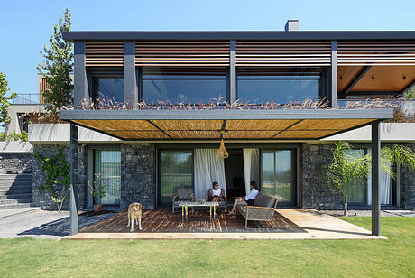 Contemporary design with wooden louvers, stone accents, and an expansive covered patio.