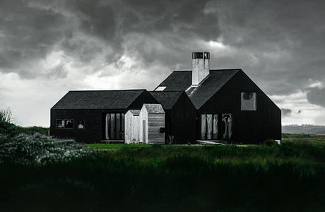 Dark, rustic buildings with distinctive angles and shapes under a stormy sky.