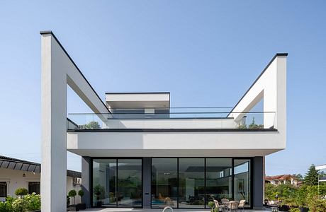 Modern architectural design with sleek, angular lines, glass walls, and swimming pool.