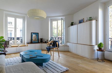 Bright, airy living room with large windows, pendant light, and contemporary furniture.