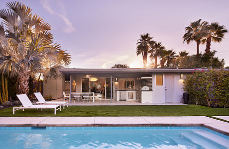 Streamlined midcentury-style home with open floor plan, pool, and lush landscaping.