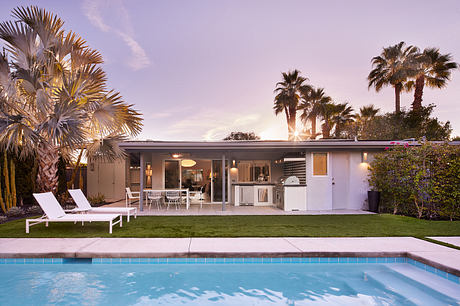 Streamlined midcentury-style home with open floor plan, pool, and lush landscaping.