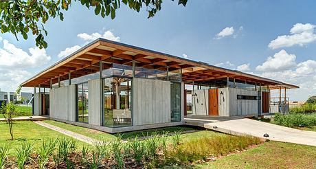 A modern, modular structure with open interiors and a striking wooden canopy roof.