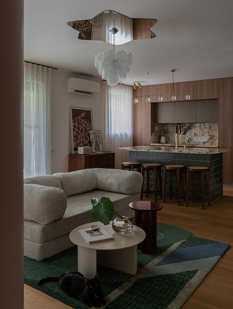 Stylish living room with modern furnishings, sleek kitchen, and intriguing lighting fixture.