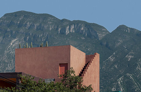 Striking architectural design with stepped exterior, set against dramatic mountainous backdrop.