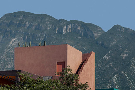 Striking architectural design with stepped exterior, set against dramatic mountainous backdrop.