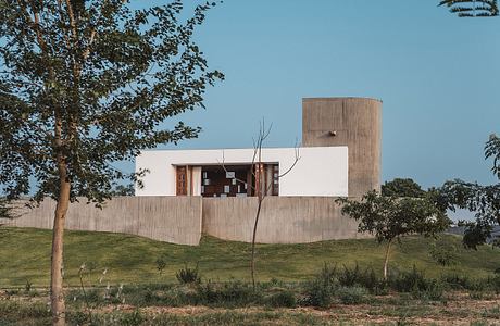 A modernist concrete structure with a white facade and distinctive window patterns.