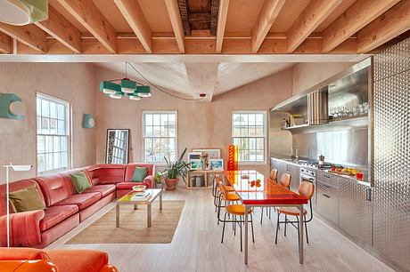 Warm, vibrant open-plan living space with wooden beams, bright furnishings, and modern kitchen.