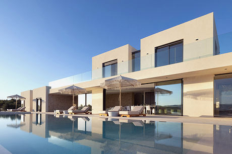 Modern beachside villa with sleek architecture, an inviting pool, and stylish outdoor seating.