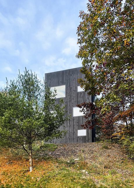 Modern wooden building nestled amidst vibrant fall foliage, showcasing architectural elements.