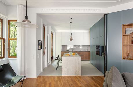 A modern, open-concept kitchen and dining space with gray cabinetry, wooden accents.