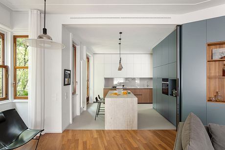 A modern, open-concept kitchen and dining space with gray cabinetry, wooden accents.