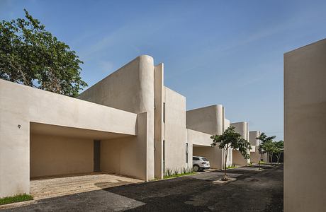 Concrete structures with clean angular lines, punctuated by trees and asphalt roads.