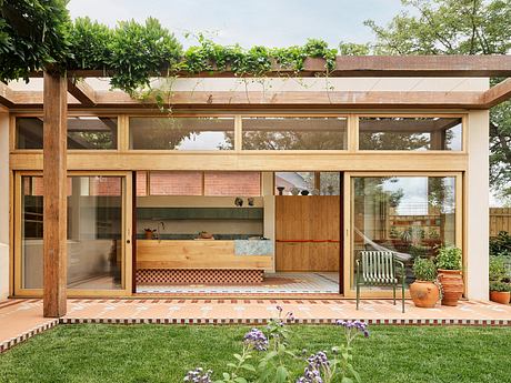 Warm, modern architectural design with wood, glass, and brick elements. Cozy outdoor seating area.