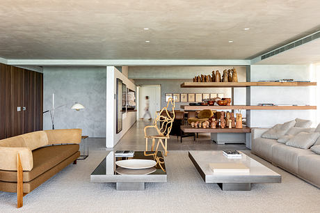 Spacious modern living room with concrete walls, wood shelving, and minimalist furnishings.