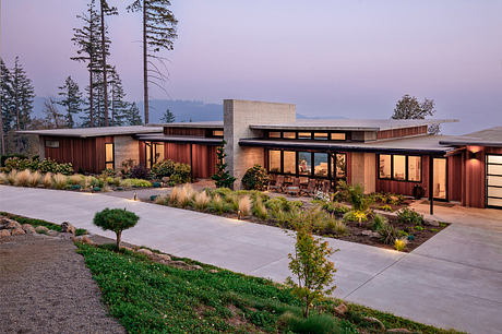 Modern, wood-paneled exterior with expansive windows, landscaped gardens, and a paved walkway.