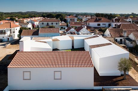 Charming village with traditional terracotta-tiled roofs and modern white architecture.