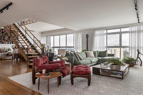 Spacious living room with modern furniture, sleek stairs, and expansive windows.