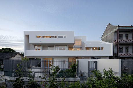 An angular, white modern home with a multilayered facade and prominent balconies.